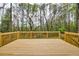 New, spacious wood deck with railing overlooks a private, wooded backyard, perfect for outdoor enjoyment at 2611 Rock Point Ln, Snellville, GA 30039