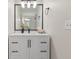 Bright bathroom featuring a white vanity with black hardware, a black framed mirror and modern lighting at 2611 Rock Point Ln, Snellville, GA 30039