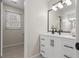 Bright bathroom featuring a white vanity with black hardware, a black framed mirror and modern lighting at 2611 Rock Point Ln, Snellville, GA 30039