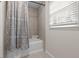 Bathroom with a tub and tiled shower, a shower curtain and a window at 2611 Rock Point Ln, Snellville, GA 30039