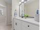 Bathroom vanity featuring white cabinets, granite countertop, dark hardware, and modern fixtures at 2611 Rock Point Ln, Snellville, GA 30039