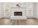 Bright living room with a white painted brick fireplace and views from large windows at 2611 Rock Point Ln, Snellville, GA 30039