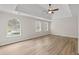 Spacious main bedroom featuring tray ceilings, ceiling fan, beautiful windows, and light wood flooring at 2611 Rock Point Ln, Snellville, GA 30039
