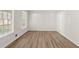 Bright room with laminate floors and two windows bringing in natural light at 2611 Rock Point Ln, Snellville, GA 30039