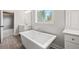 Bright bathroom with a soaking tub, vanity, and a view to the outdoors at 3330 Hillshire Dr, Cumming, GA 30028