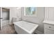 Bright bathroom featuring soaking tub, gray tile flooring, and a view to the bedroom at 3330 Hillshire Dr, Cumming, GA 30028