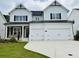 Striking two-story modern farmhouse with a white exterior, black accents, and a spacious two-car garage at 3330 Hillshire Dr, Cumming, GA 30028