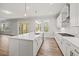 Open kitchen with island, stainless steel hood, white cabinets, and modern pendant lighting at 3330 Hillshire Dr, Cumming, GA 30028