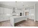 Elegant kitchen showcasing a spacious island, white cabinetry, and modern pendant lighting at 3330 Hillshire Dr, Cumming, GA 30028