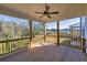 Covered porch with a ceiling fan and wood flooring, offering stunning views of the wooded surroundings at 3330 Hillshire Dr, Cumming, GA 30028