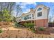 A house boasts a beautiful backyard featuring a deck, mature landscaping, and mulched flowerbeds at 4840 Brent Knoll Ln, Suwanee, GA 30024