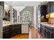 Open kitchen with dark cabinets, stainless steel appliances, and view into the dining room at 4840 Brent Knoll Ln, Suwanee, GA 30024