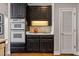 Kitchen featuring stainless appliances, stylish backsplash, and access to additional storage at 4840 Brent Knoll Ln, Suwanee, GA 30024