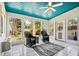Charming sunroom with tiled floors, blue ceiling, ceiling fan, and nature views from windows at 4840 Brent Knoll Ln, Suwanee, GA 30024