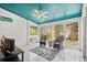 Bright sunroom with white flooring, blue ceiling, ceiling fan, and windows with views of nature at 4840 Brent Knoll Ln, Suwanee, GA 30024