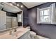Modern bathroom with neutral vanity, sink, mirror, window, shower with glass door and white tile floor at 910 Brentwood Ave, Lawrenceville, GA 30044