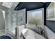 Sleek bathroom featuring soaking tub, shower, frosted window for privacy and stylish tile accents at 910 Brentwood Ave, Lawrenceville, GA 30044