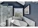 Sleek bathroom featuring soaking tub, shower, frosted window for privacy and stylish tile accents at 910 Brentwood Ave, Lawrenceville, GA 30044