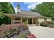Stunning exterior featuring a stone chimney, covered porch, and beautifully landscaped yard at 910 Brentwood Ave, Lawrenceville, GA 30044