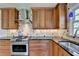 Kitchen featuring stainless steel range, custom hood, and corner sink with wooden cabinets at 910 Brentwood Ave, Lawrenceville, GA 30044