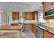 Open kitchen with stainless steel appliances, wooden cabinets, and view to the living room at 910 Brentwood Ave, Lawrenceville, GA 30044
