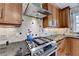 Close-up of the kitchen featuring a stainless steel range, custom hood, and beautiful granite countertops at 910 Brentwood Ave, Lawrenceville, GA 30044