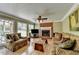 Cozy living room with a brick fireplace, hardwood floors, and large windows overlooking the backyard at 910 Brentwood Ave, Lawrenceville, GA 30044