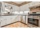 Kitchen featuring white cabinets, stainless appliances, and brick accent wall at 1309 Brookshire Ne Ln, Brookhaven, GA 30319