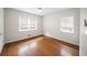 Bright bedroom featuring two windows, hardwood floors, white walls and a ceiling fan at 1323 Christmas Ne Ln, Atlanta, GA 30329