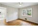 Bedroom features hardwood floors, a window with blinds, and a connecting door to the kitchen at 1323 Christmas Ne Ln, Atlanta, GA 30329