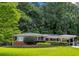 Charming brick home with well-maintained landscaping and a convenient carport, nestled among mature trees at 1323 Christmas Ne Ln, Atlanta, GA 30329