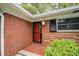 Front entrance with red brick wall, updated front door, and shuttered window at 1323 Christmas Ne Ln, Atlanta, GA 30329