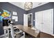 A well-lit home office with contemporary desk, custom light fixture and whimsical wall art at 2013 Rockledge Ne Rd, Atlanta, GA 30324