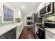 Modern kitchen with stainless steel appliances, white cabinetry, quartz countertops, and a tile backsplash at 2903 Akron Street, East Point, GA 30344