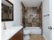 Tiled bathroom showcasing a tub-shower combo, vanity, and mirror at 64 Saint Claire Ne Ln, Atlanta, GA 30324