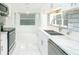Elegant kitchen with white cabinets, stainless steel appliances, stone countertops, and tiled floors, blending style with functionality at 64 Saint Claire Ne Ln, Atlanta, GA 30324