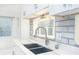 Bright kitchen featuring white cabinets, modern countertops, stainless steel faucet, and a window above the sink at 64 Saint Claire Ne Ln, Atlanta, GA 30324