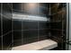 Sleek shower featuring black tiling, a built-in seat, and modern fixtures, offering a luxurious bathing experience at 64 Saint Claire Ne Ln, Atlanta, GA 30324