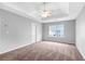 Carpeted bedroom featuring a tray ceiling, ceiling fan, and natural light at 2760 Carolina Rdg, Riverdale, GA 30296
