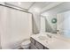 Neutral toned bathroom featuring a large vanity mirror and a shower with a white curtain at 399 Se Skylar Way, Atlanta, GA 30315