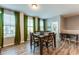 Well-lit dining area with wood flooring, a table with chairs, and view of large windows at 399 Se Skylar Way, Atlanta, GA 30315