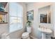 Tastefully decorated powder room with a pedestal sink, decorative mirror, and shelving at 399 Se Skylar Way, Atlanta, GA 30315