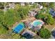 Aerial view of a home with a pool, tennis court, deck, and wooded surroundings at 4103 Devon Wood Ne Dr, Marietta, GA 30066