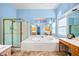 Bright bathroom featuring a soaking tub, glass-enclosed shower, and light blue walls at 4103 Devon Wood Ne Dr, Marietta, GA 30066