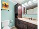 Well-lit bathroom with dark wood cabinets, granite countertop, and a decorative painting at 4103 Devon Wood Ne Dr, Marietta, GA 30066