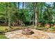 Stone firepit area surrounded by trees, creating a cozy outdoor gathering space at 4103 Devon Wood Ne Dr, Marietta, GA 30066
