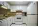 Compact kitchen featuring granite countertops, white appliances, and ample cabinet space at 1800 Clairmont Lk # 221, Decatur, GA 30033