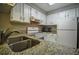 Compact kitchen featuring granite countertops, white appliances, and ample cabinet space at 1800 Clairmont Lk # 221, Decatur, GA 30033