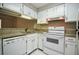 Compact kitchen featuring granite countertops, white appliances, and ample cabinet space at 1800 Clairmont Lk # 221, Decatur, GA 30033