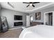 Neutral-toned main bedroom featuring ceiling fan, modern fireplace, TV, and en-suite access at 3673 Madison St, Atlanta, GA 30337